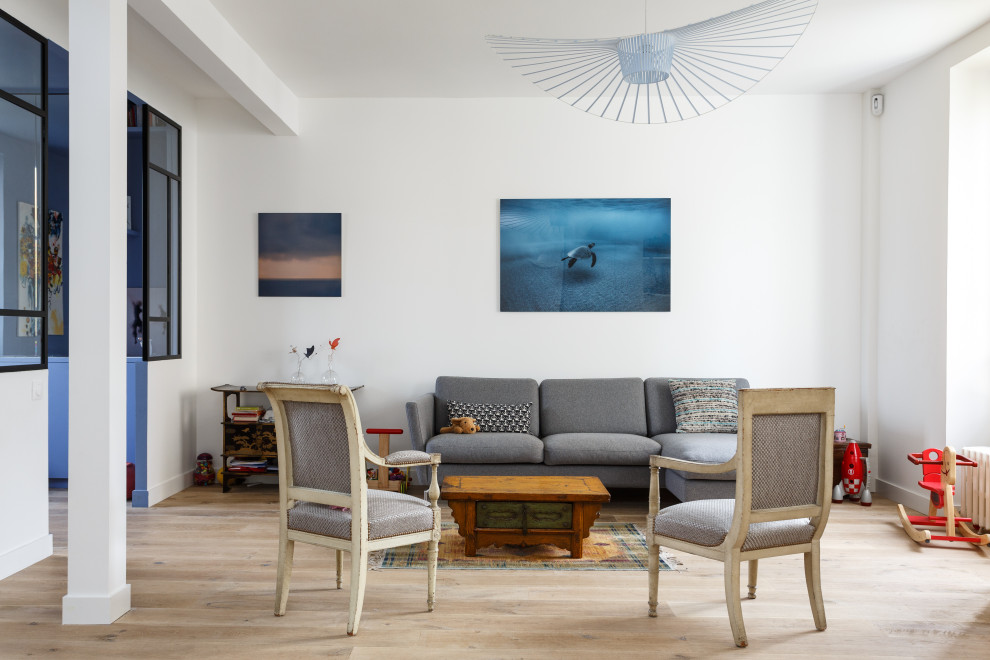 Diseño de sala de estar abierta escandinava sin chimenea con paredes blancas y suelo de madera clara