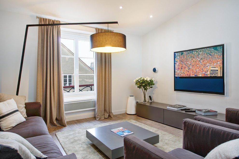 Immagine di un soggiorno contemporaneo di medie dimensioni e chiuso con pareti bianche, pavimento in legno massello medio e TV a parete