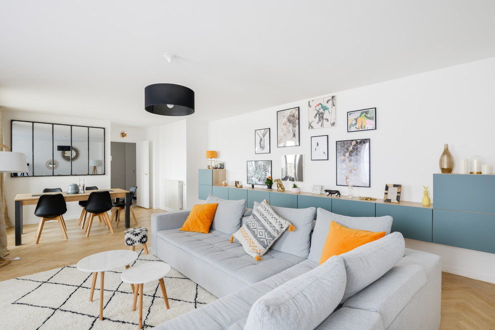 Aménagement d'une salle de séjour contemporaine avec un mur blanc, parquet clair et un sol beige.