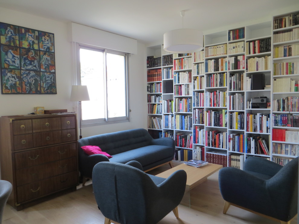 Foto di un soggiorno minimal di medie dimensioni e chiuso con libreria, pareti bianche, parquet chiaro, nessuna TV e pavimento beige