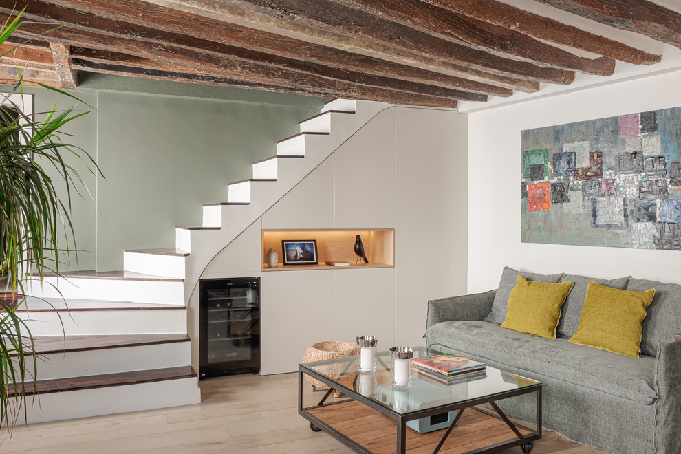 Idée de décoration pour une salle de séjour design ouverte avec un mur blanc, parquet clair et un sol beige.