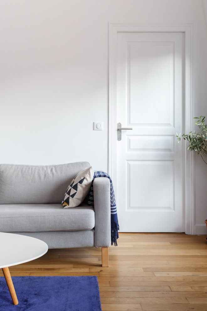 Exemple d'une salle de séjour moderne de taille moyenne et ouverte avec un mur blanc, un sol en bois brun, une cheminée standard, un manteau de cheminée en pierre, un téléviseur indépendant et un sol marron.