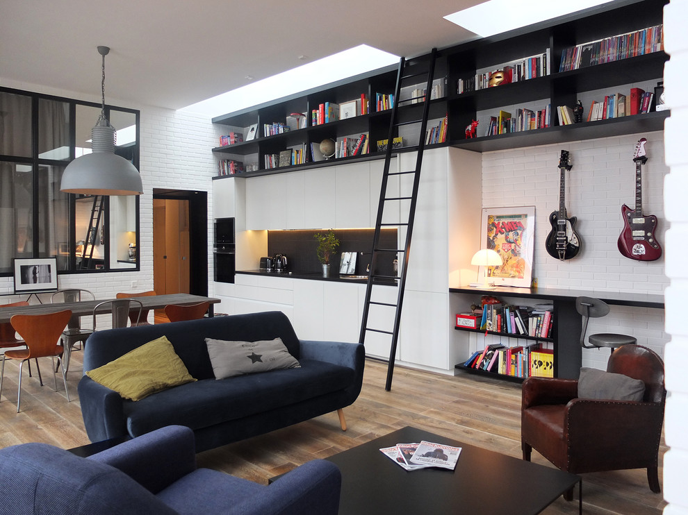 Imagen de sala de estar con rincón musical abierta industrial de tamaño medio sin chimenea con paredes blancas y suelo de madera clara