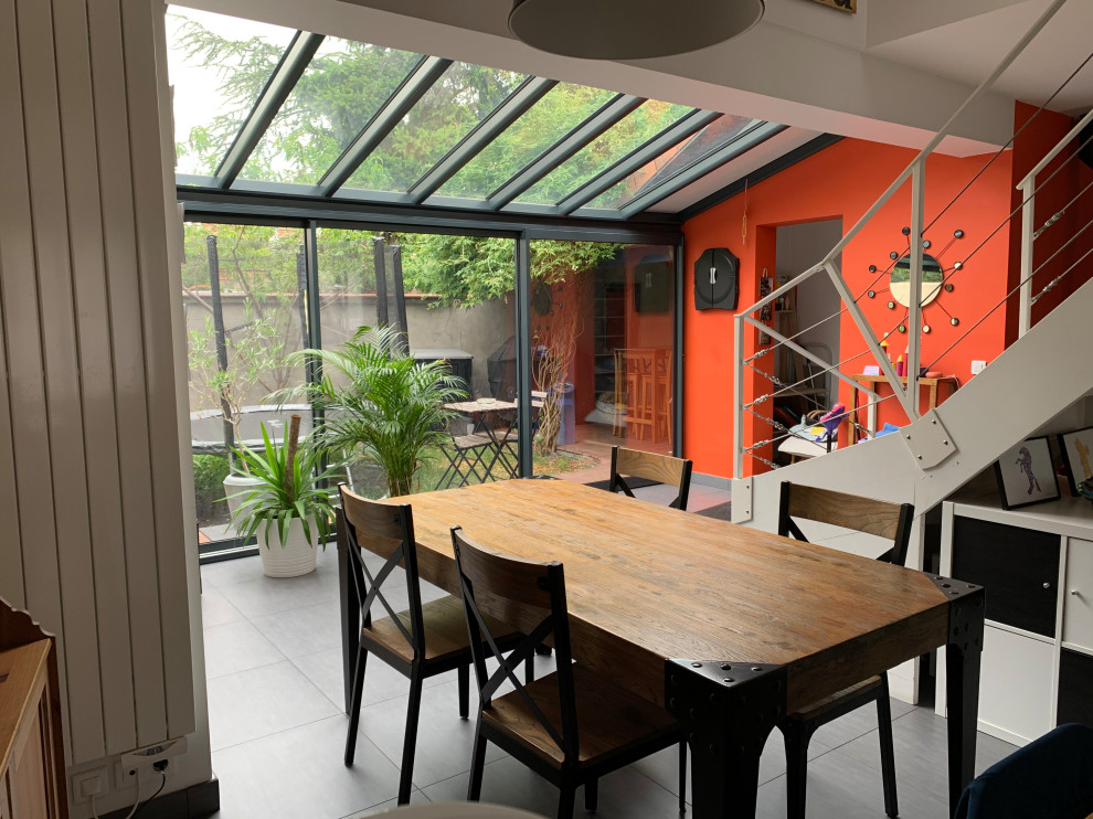 Exemple d'une salle de séjour tendance de taille moyenne et ouverte avec un poêle à bois, un sol gris, un mur orange, sol en béton ciré et aucun téléviseur.