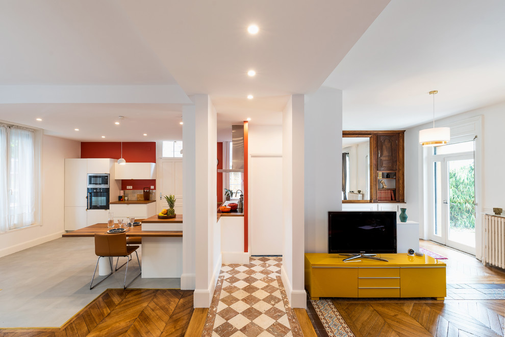 Großes Stilmix Wohnzimmer ohne Kamin mit weißer Wandfarbe, braunem Holzboden, freistehendem TV und braunem Boden in Sonstige