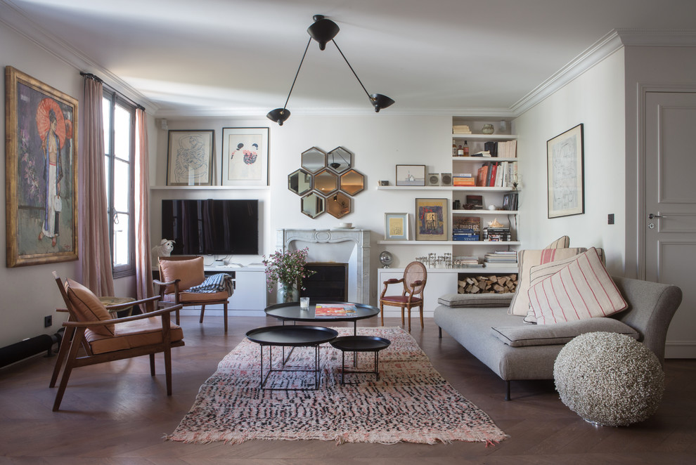 Esempio di un soggiorno chic aperto con pareti bianche, camino classico, TV a parete, pavimento marrone e libreria