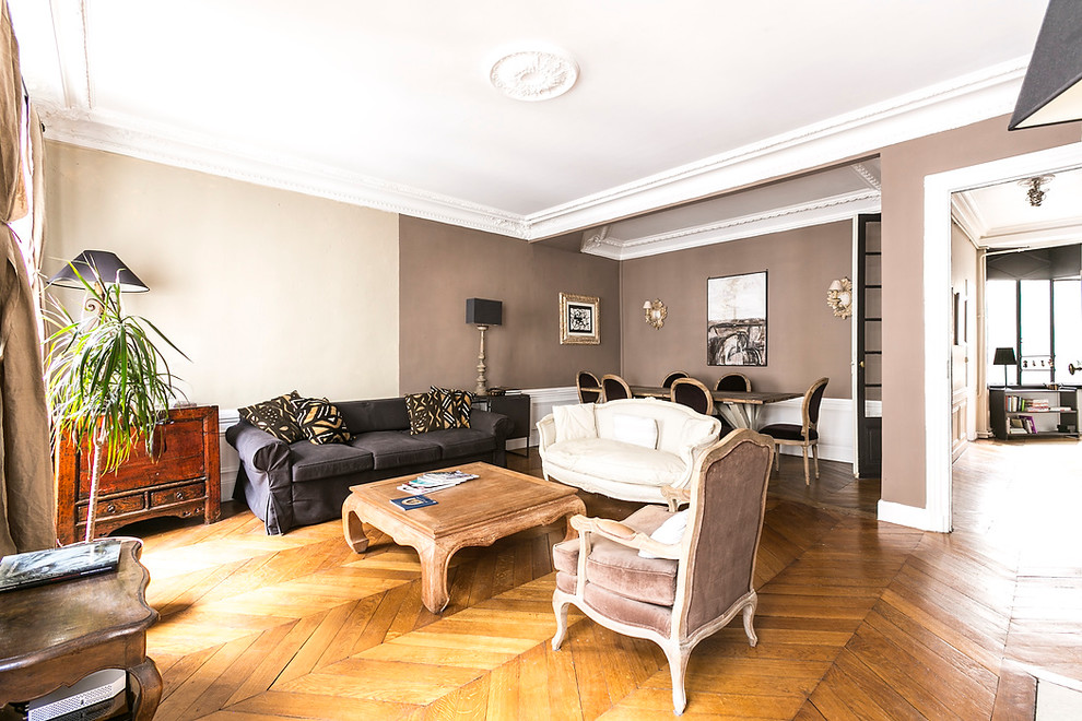 Imagen de sala de estar abierta clásica renovada grande sin televisor con paredes beige y suelo de madera en tonos medios