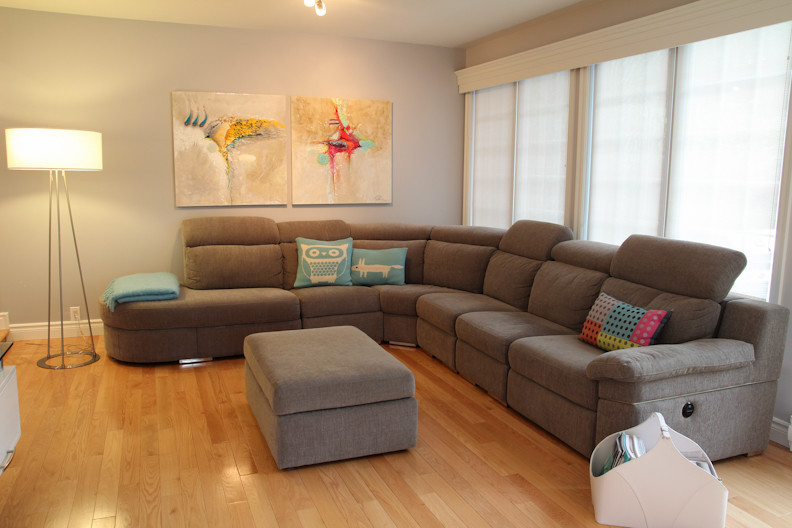 Foto di un soggiorno design aperto e di medie dimensioni con pareti grigie, parquet chiaro, TV a parete e pavimento beige