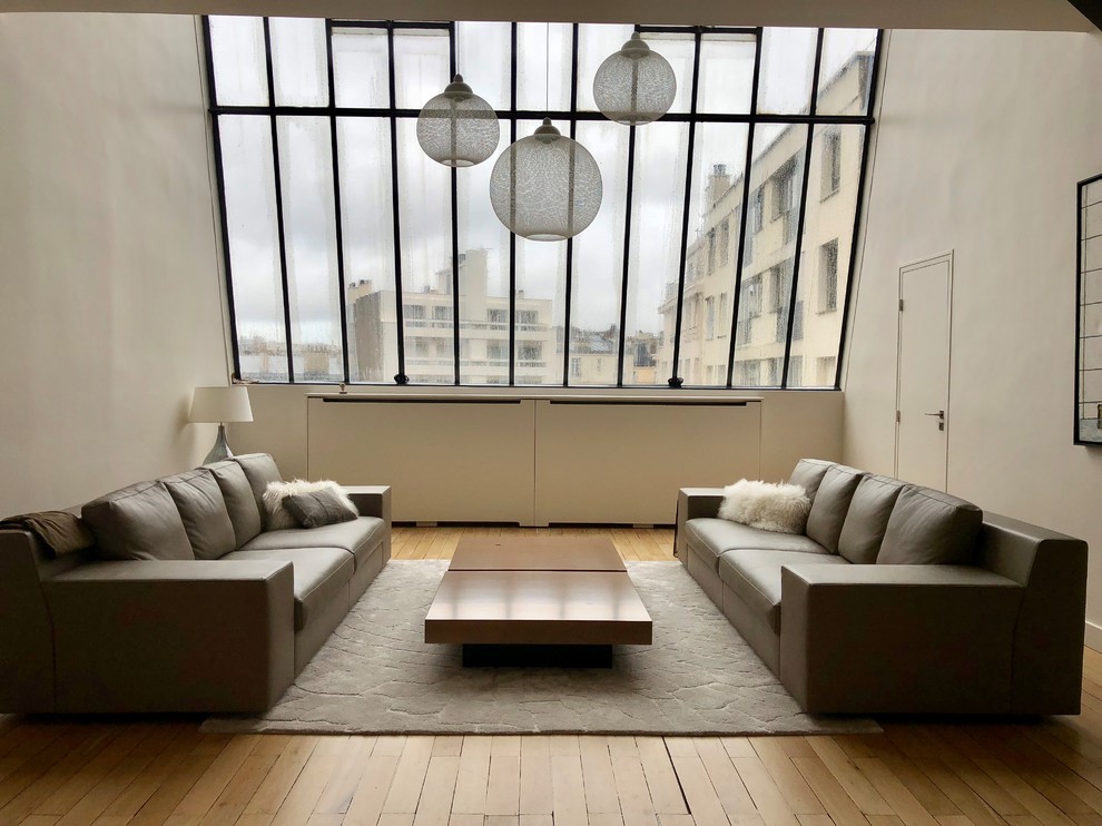 Foto di un grande soggiorno moderno stile loft con pavimento in legno verniciato