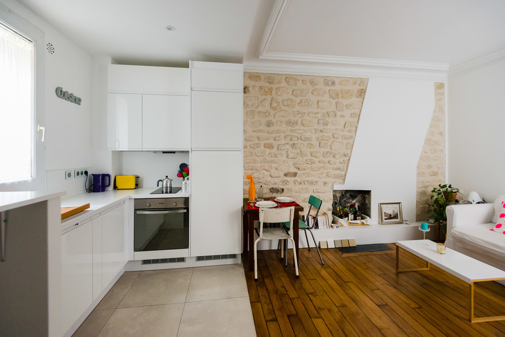 Ejemplo de sala de estar abierta pequeña con suelo de madera en tonos medios, estufa de leña, paredes blancas y marco de chimenea de ladrillo