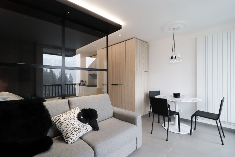 На фото: маленькая гостиная комната в стиле рустика с белыми стенами, полом из керамической плитки и серым полом для на участке и в саду с