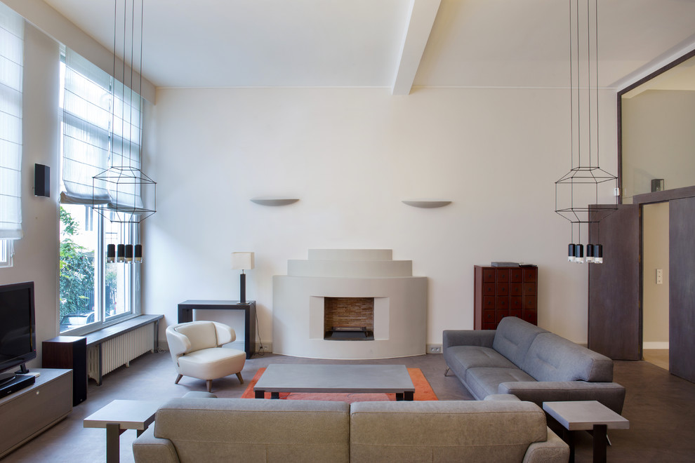 Immagine di un grande soggiorno design chiuso con pareti beige, camino classico, cornice del camino in intonaco e TV autoportante