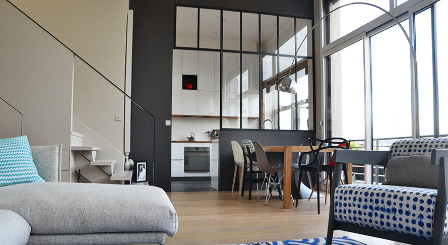 Idee per un grande soggiorno design aperto con pareti beige, parquet chiaro, cornice del camino in intonaco e TV nascosta