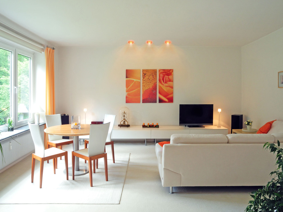Ejemplo de sala de estar con biblioteca abierta contemporánea de tamaño medio sin chimenea con paredes blancas, televisor independiente y suelo de cemento