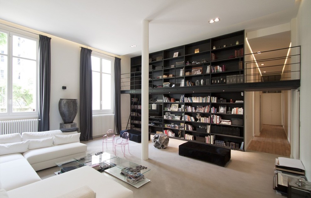 Ejemplo de sala de estar con biblioteca abierta industrial grande sin chimenea y televisor con paredes blancas y moqueta