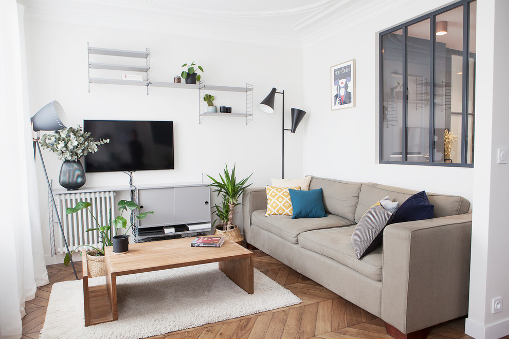 Small danish light wood floor and brown floor family room photo in Paris with a wall-mounted tv and white walls