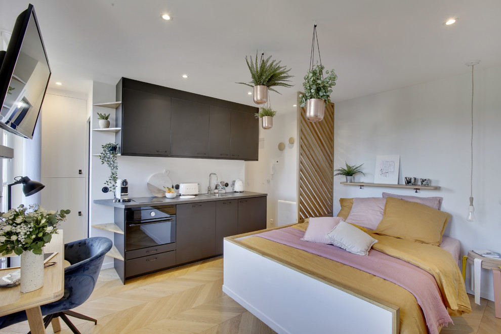 Exemple d'une petite salle de séjour éclectique ouverte avec un mur blanc, parquet clair, aucune cheminée, un téléviseur fixé au mur et un sol beige.