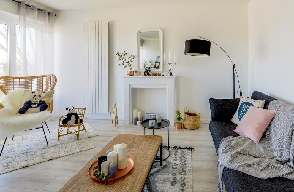 Immagine di un soggiorno scandinavo di medie dimensioni e aperto con pareti bianche, pavimento in laminato, cornice del camino in legno, TV autoportante, pavimento grigio e camino classico