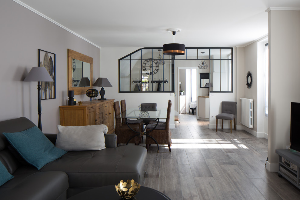На фото: большая открытая гостиная комната в стиле неоклассика (современная классика) с серыми стенами, полом из керамической плитки, угловым камином, фасадом камина из камня и серым полом