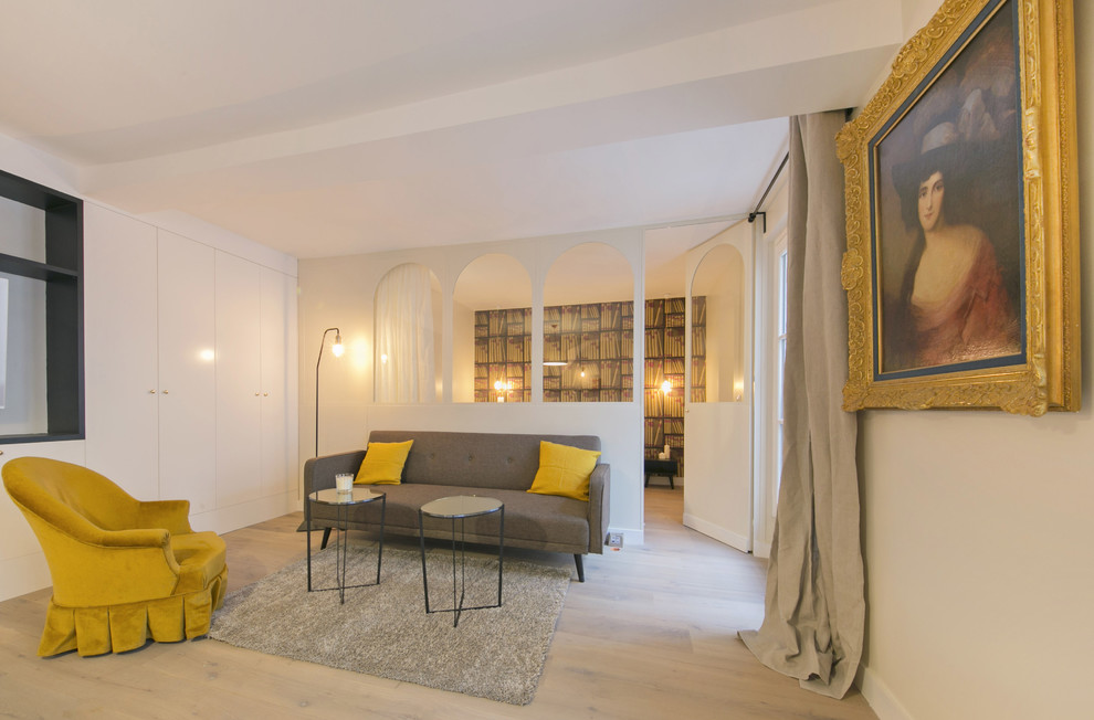 Photo of a small contemporary enclosed games room in Paris with a reading nook, beige walls, light hardwood flooring, no fireplace, a wall mounted tv and beige floors.