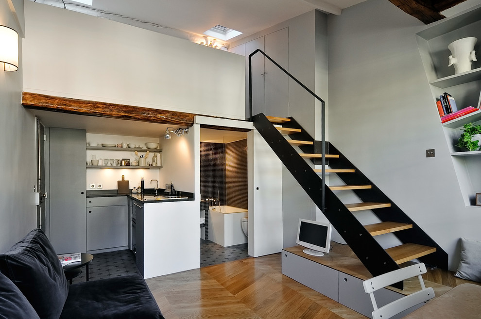 Foto de sala de estar abierta contemporánea de tamaño medio sin televisor con paredes grises y suelo de madera en tonos medios