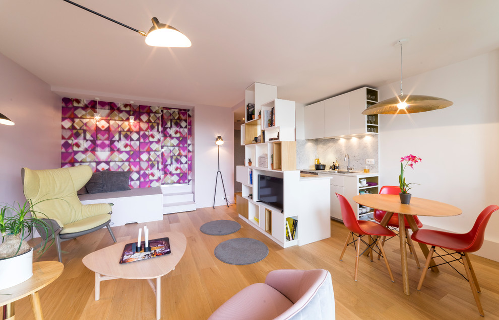Пример оригинального дизайна: маленькая открытая гостиная комната в современном стиле с с книжными шкафами и полками, розовыми стенами, светлым паркетным полом, мультимедийным центром и коричневым полом без камина для на участке и в саду