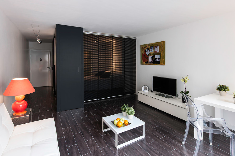 Imagen de sala de estar abierta contemporánea pequeña con paredes blancas, suelo de baldosas de porcelana, televisor independiente y suelo marrón