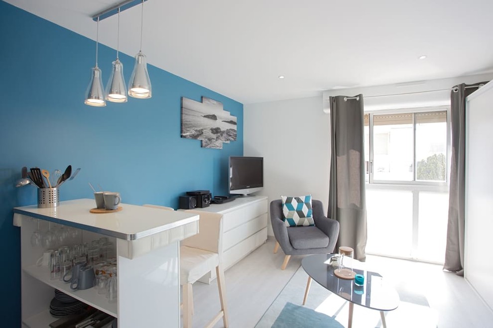 Réalisation d'une petite salle de séjour design ouverte avec un mur bleu, un sol en linoléum, aucune cheminée et un téléviseur indépendant.