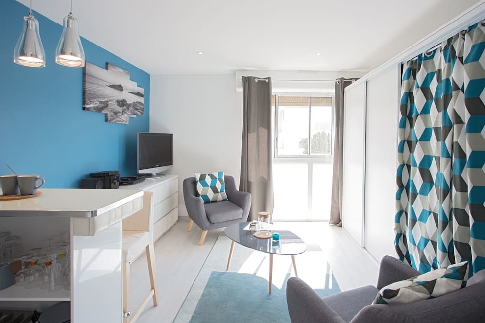 Пример оригинального дизайна: маленькая открытая гостиная комната в современном стиле с синими стенами, полом из линолеума и отдельно стоящим телевизором без камина для на участке и в саду