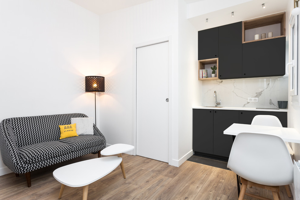 Ejemplo de sala de estar abierta actual pequeña sin chimenea con paredes blancas, suelo de madera clara, televisor independiente y suelo beige