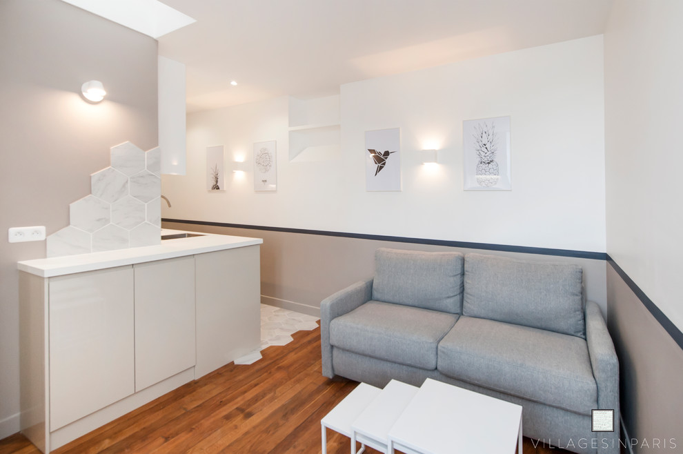 Esempio di un soggiorno minimal di medie dimensioni e aperto con pareti bianche, pavimento in legno massello medio, TV autoportante e pavimento beige