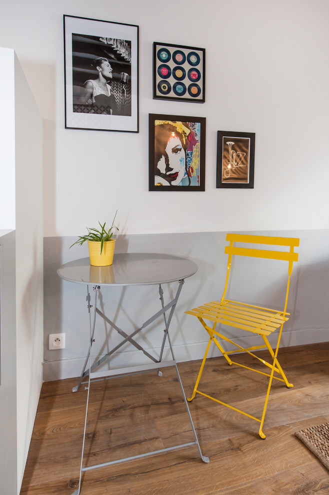 Cette image montre une salle de séjour design de taille moyenne et ouverte avec un mur multicolore, un sol en bois brun, un téléviseur indépendant et un sol beige.