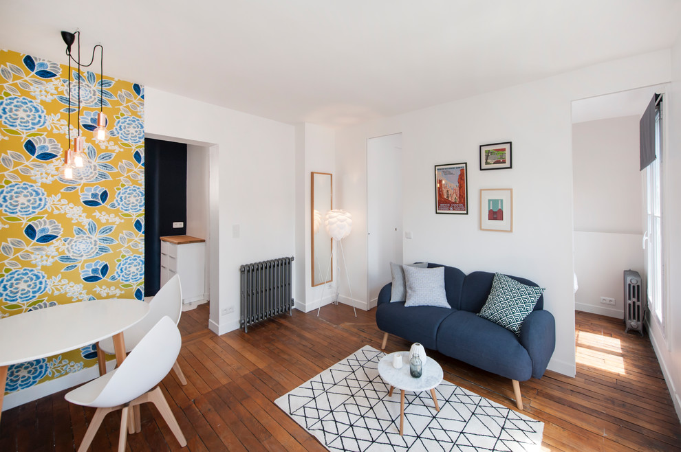 Cette image montre une salle de séjour design de taille moyenne et ouverte avec un mur blanc, un sol en bois brun et un sol beige.