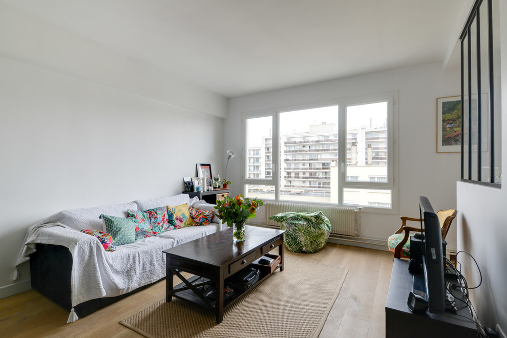 Example of a mid-sized trendy open concept light wood floor family room design in Paris with white walls
