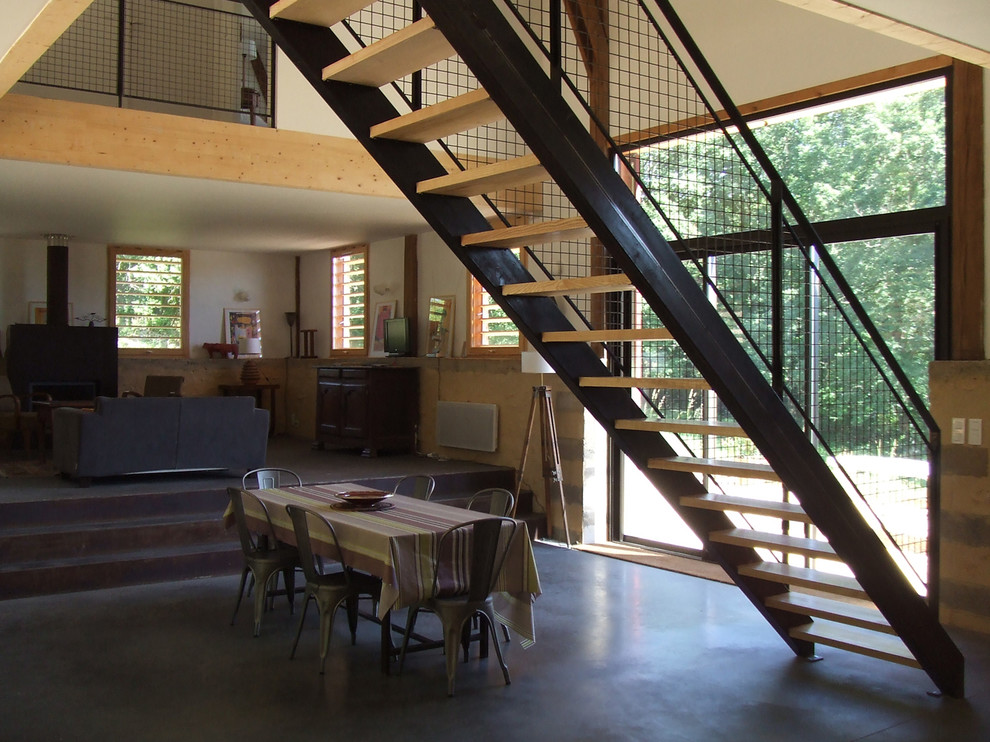 Mittelgroßes Modernes Wohnzimmer im Loft-Stil mit Hausbar, Betonboden, Kaminofen, Kaminumrandung aus Metall und schwarzem Boden in Bordeaux