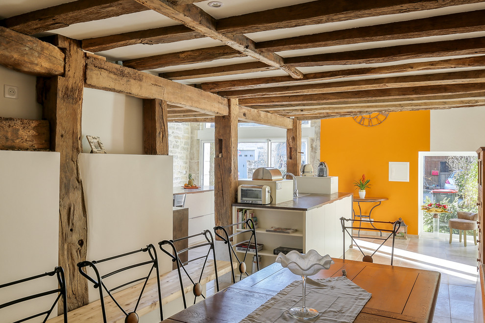 Cette photo montre une grande salle de séjour chic ouverte avec un mur beige, un sol en carrelage de céramique et un sol beige.