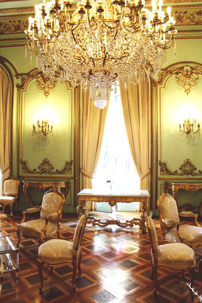 Imagen de sala de estar abierta tradicional renovada de tamaño medio sin chimenea y televisor con paredes verdes y suelo de madera en tonos medios