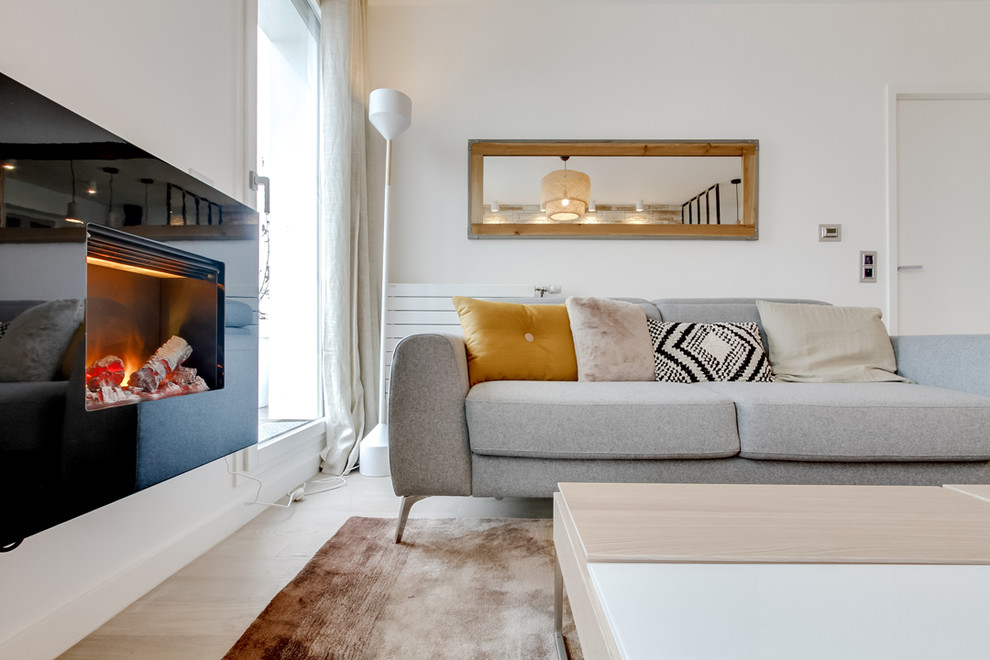 Aménagement d'un salon scandinave de taille moyenne et ouvert avec un mur blanc, parquet clair, cheminée suspendue, un manteau de cheminée en métal et un téléviseur indépendant.