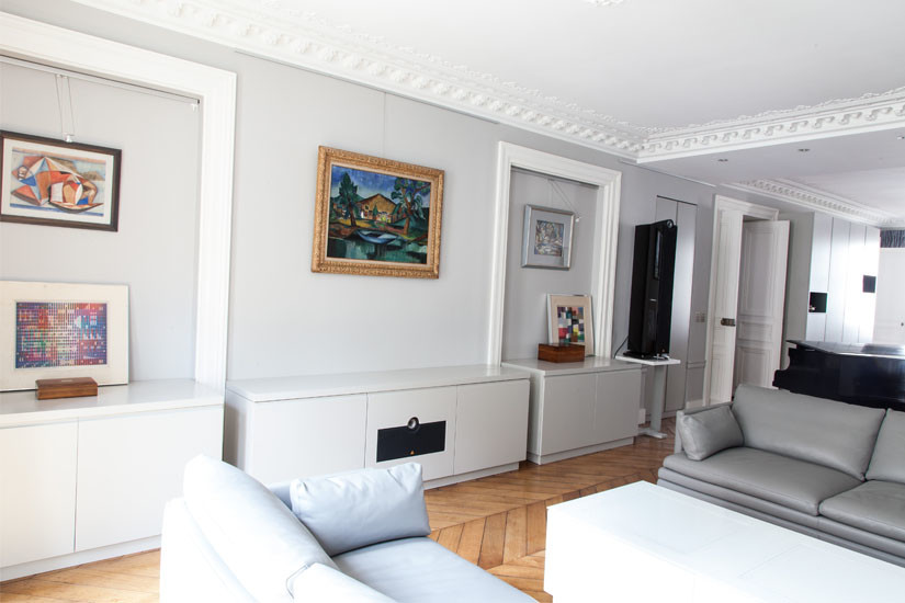 На фото: гостиная комната в современном стиле с серыми стенами и скрытым телевизором с