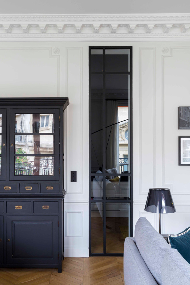 Cette image montre une salle de séjour traditionnelle de taille moyenne et ouverte avec un mur blanc, parquet clair, une cheminée standard, un manteau de cheminée en pierre et un sol beige.