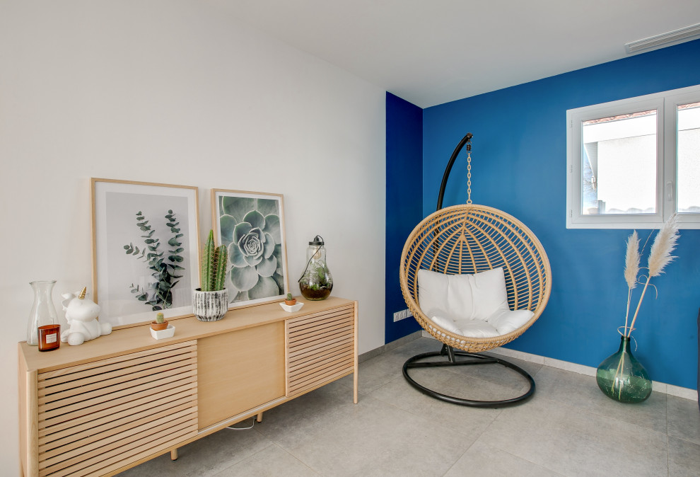 Aménagement d'une salle de séjour contemporaine de taille moyenne et ouverte avec un mur bleu et un sol gris.