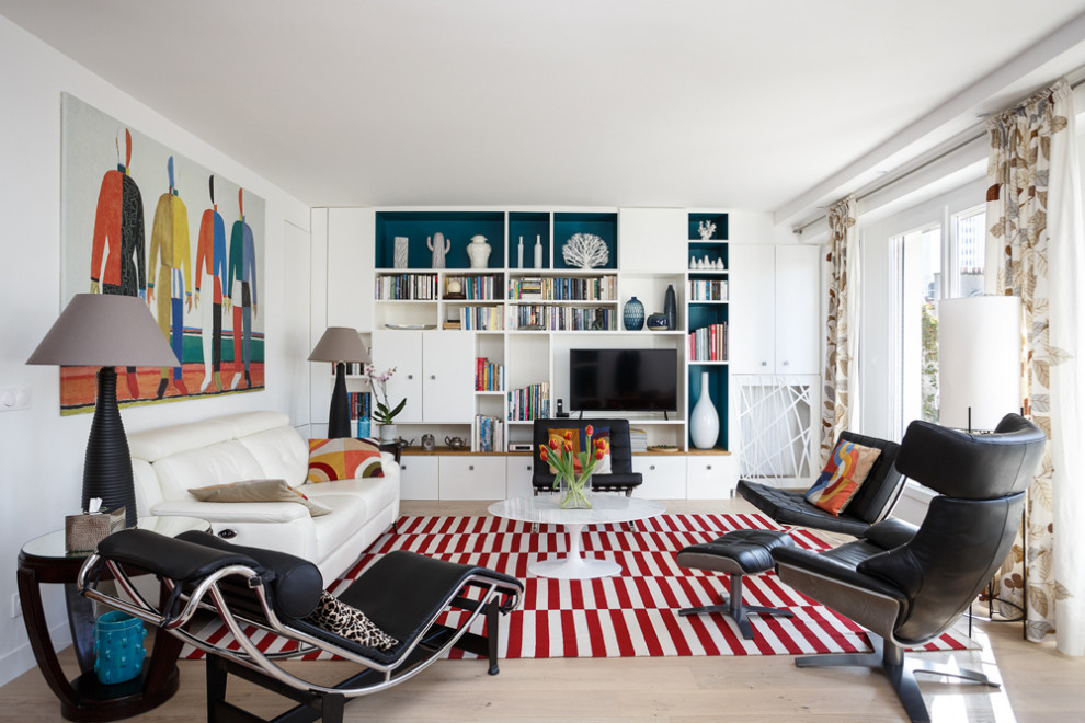 Пример оригинального дизайна: гостиная комната среднего размера в современном стиле с с книжными шкафами и полками, белыми стенами, светлым паркетным полом, отдельно стоящим телевизором и коричневым полом без камина