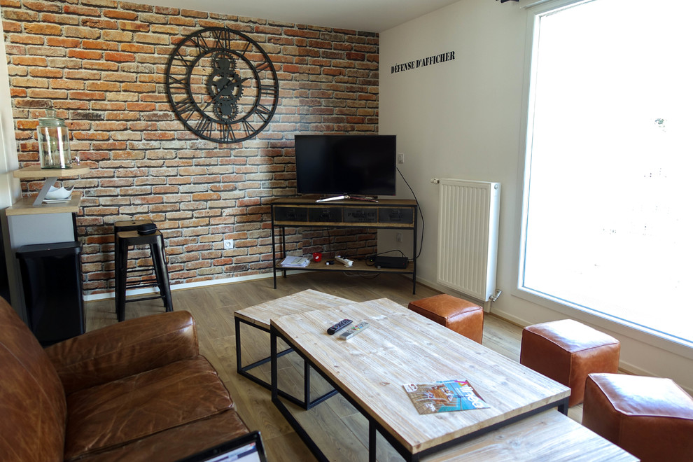 Diseño de sala de estar abierta industrial pequeña con paredes multicolor, suelo de madera clara y televisor independiente