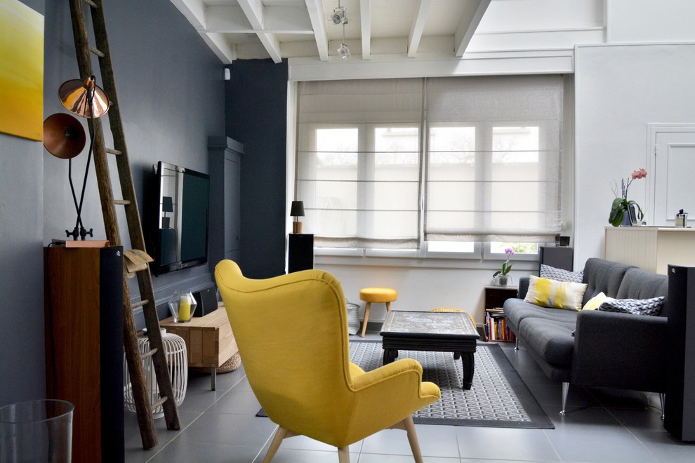 Inspiration for a large urban enclosed games room in Paris with grey walls, ceramic flooring, no fireplace, a wall mounted tv and grey floors.