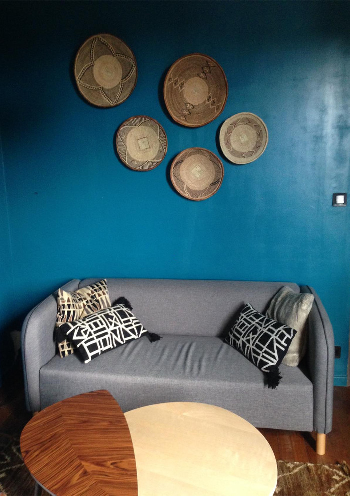 Small scandinavian open plan games room in Paris with blue walls, medium hardwood flooring and brown floors.