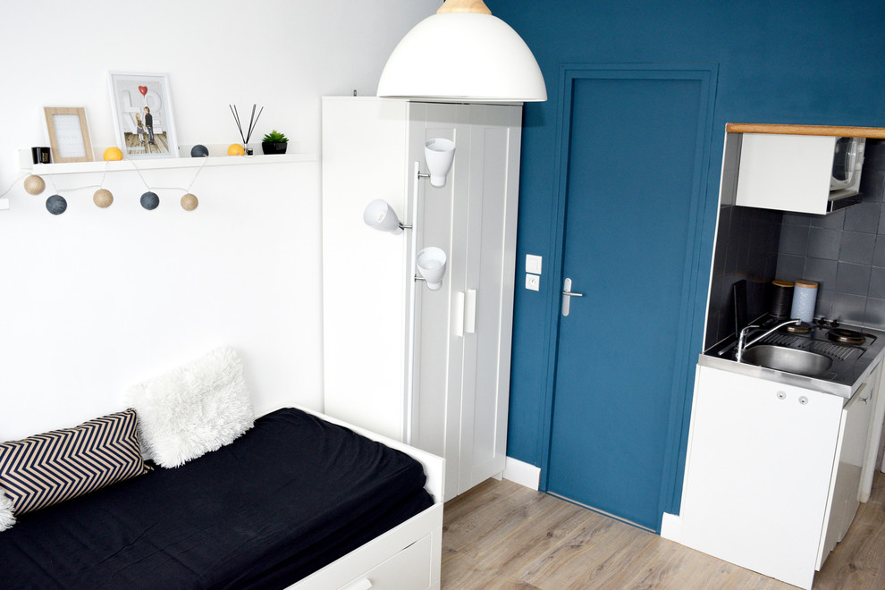 Пример оригинального дизайна: маленькая гостиная комната в скандинавском стиле с синими стенами и светлым паркетным полом для на участке и в саду