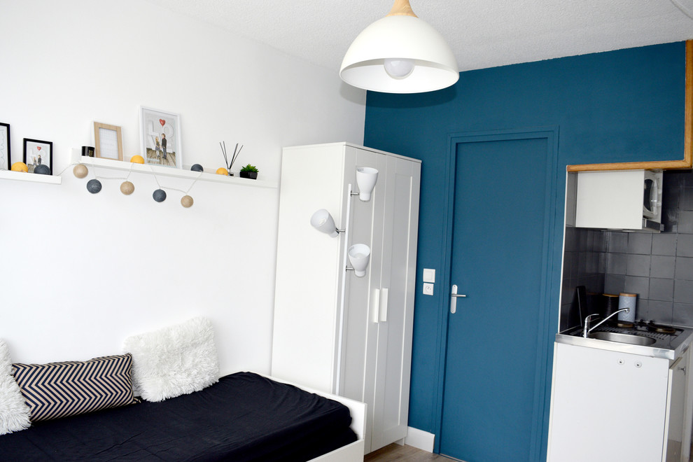Immagine di un piccolo soggiorno scandinavo con pareti blu e parquet chiaro