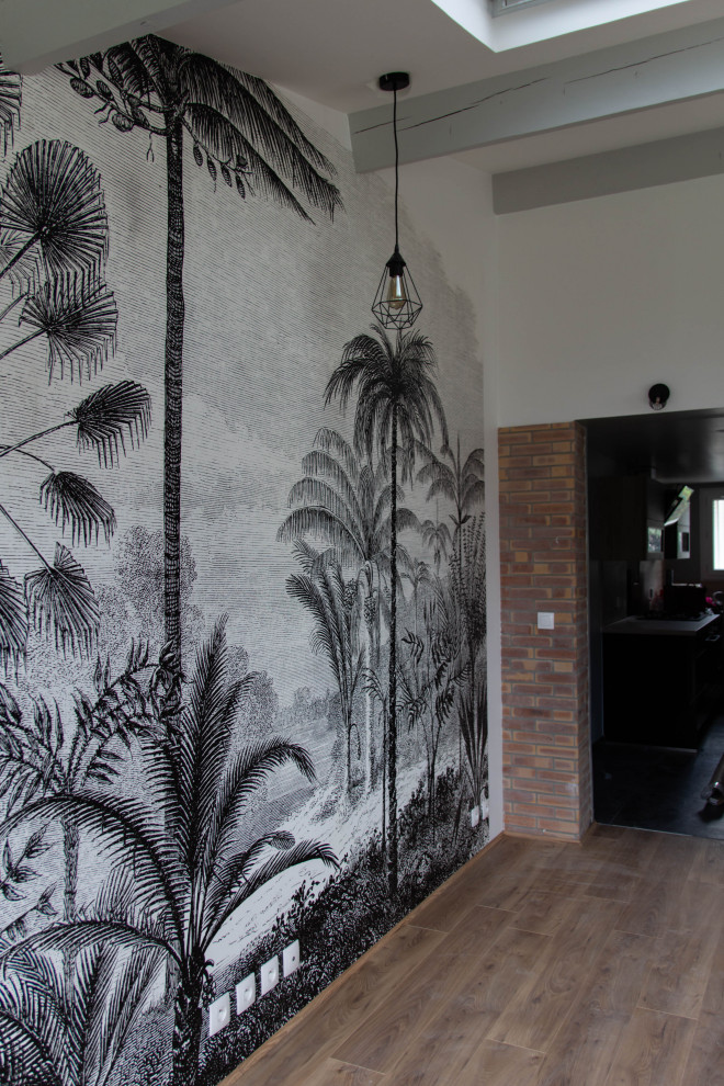 Bild på ett tropiskt allrum med öppen planlösning, med svarta väggar, ljust trägolv och beiget golv