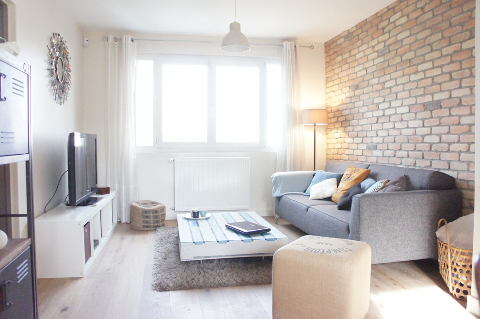 Esempio di un soggiorno industriale con pareti beige, parquet chiaro, camino classico e TV autoportante