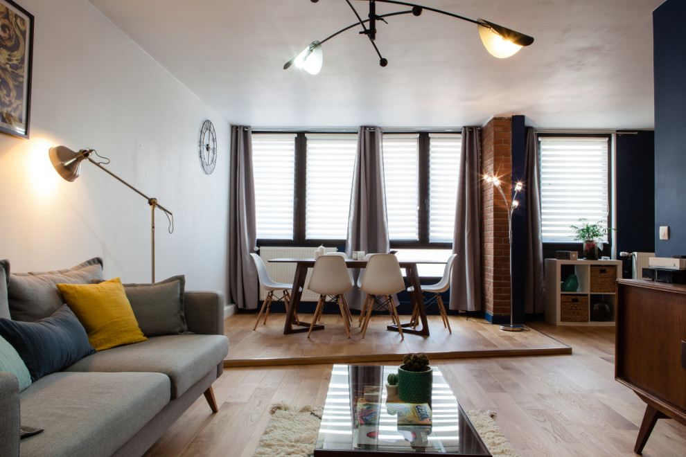 Стильный дизайн: открытая гостиная комната среднего размера в стиле ретро с синими стенами и полом из ламината - последний тренд
